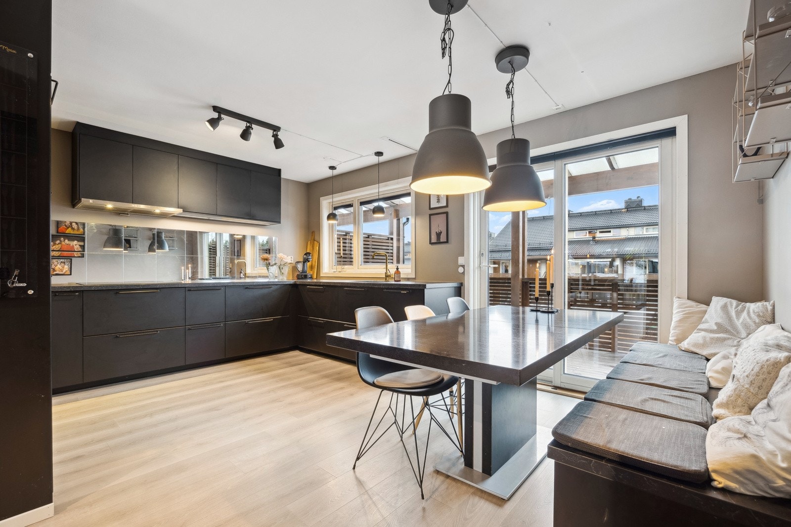 Svart kjøkkeninnredning i tidløst design, kombinert med smarte løsninger og god plass til spisebord. Galleribilde