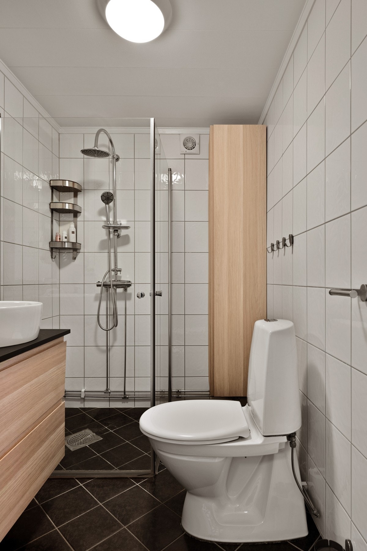 Flislagt bad med servant, dusjhjørne og toalett. Galleribilde