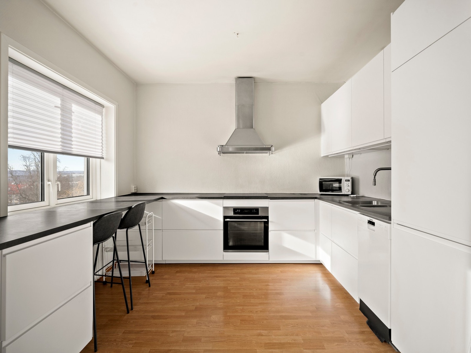 Pen Ikea kjøkkeninnredning fra 2019 med glatte fronter og laminat benkeplater. Galleribilde