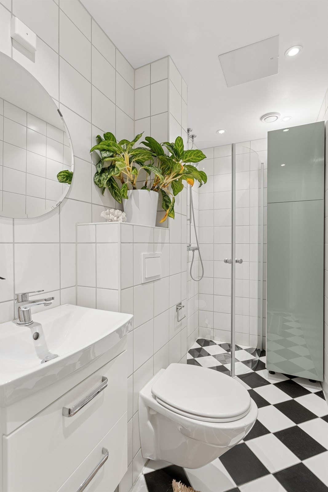 Badet er innredet med veggmontert servant med god plass til oppbevaring av baderomsartikler og toalett. Galleribilde