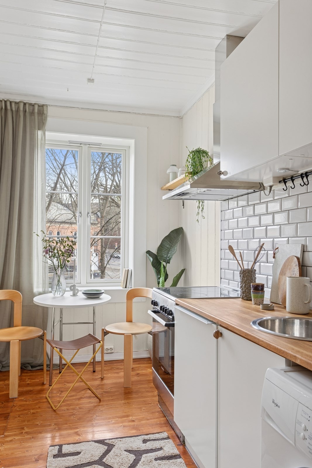 Kjøkkeninnredningen har slette fronter, overskap med benkebelysning og fliser på vegg. Galleribilde