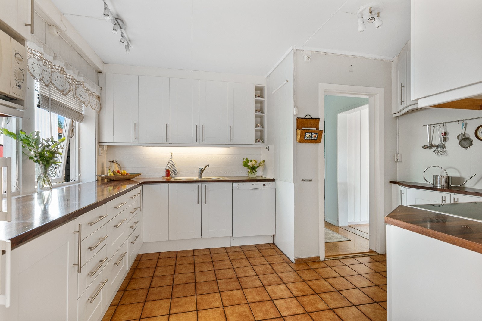 Flott kjøkken som holder et tidløst preg med sine hvite slette fronter og integrerte hvitevarer Galleribilde