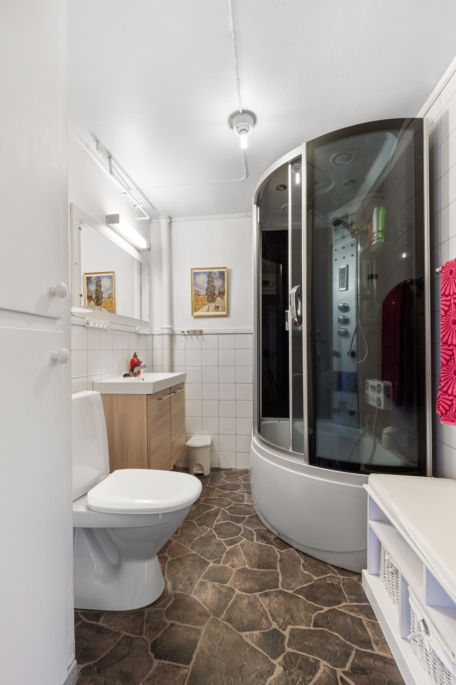 Baderommet i underetasjen vestår av servant med underskap, dusjkabinett og gulvstående toalett Galleribilde