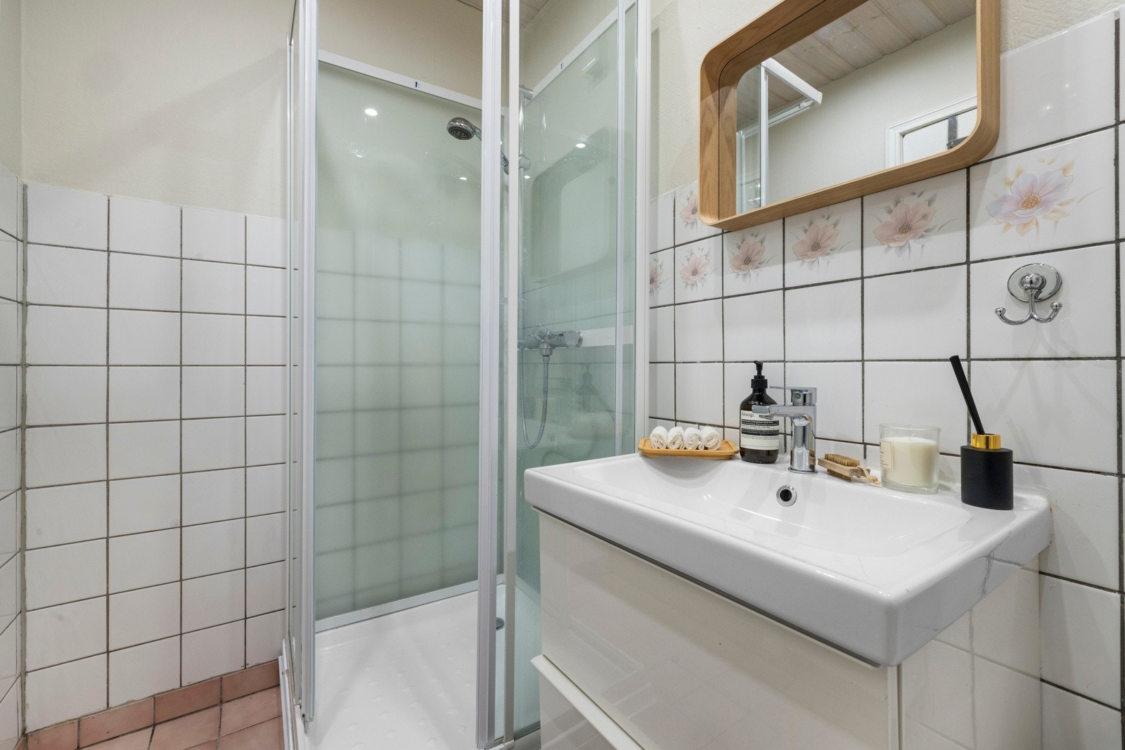 Badet har en praktisk veggehengt servant med oppbevaringsmuligeter Galleribilde