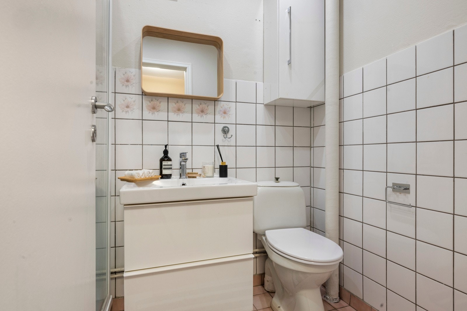 Badet har hvite keramiske fliser på vegger, med trepaneler i himlingen Galleribilde
