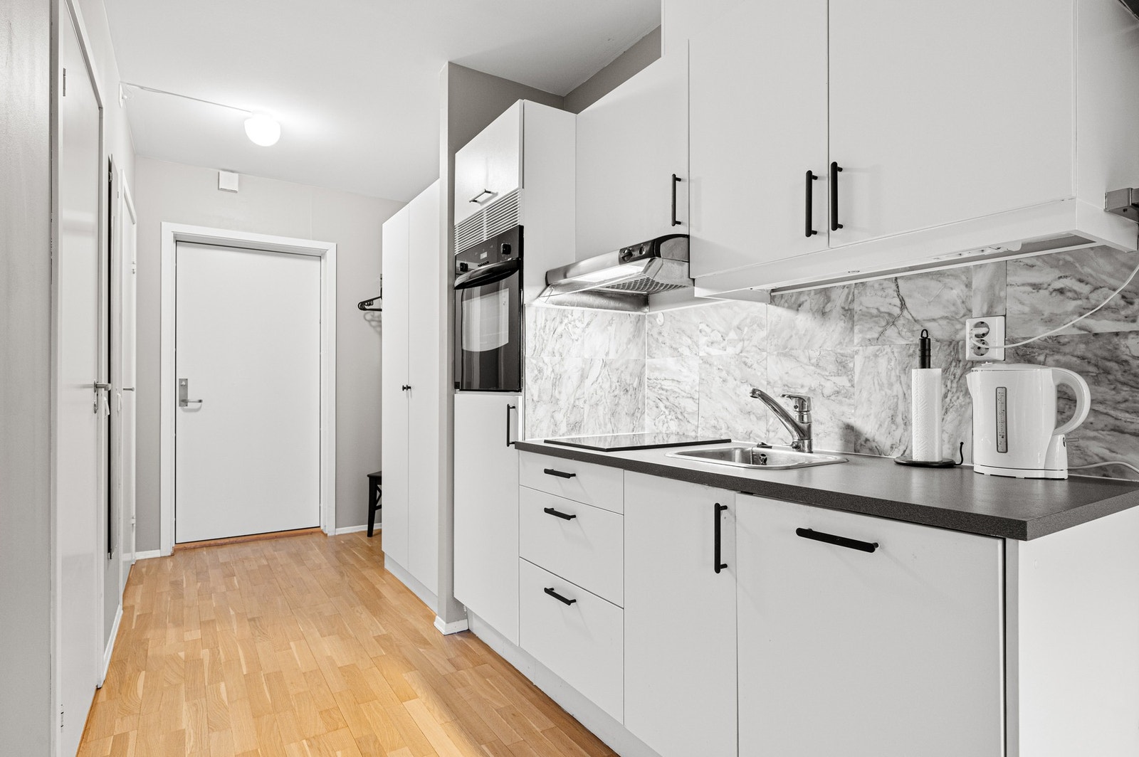 Kjøkkeninnredning med plane malte fronter, folierte skrog og laminert benkeplate. Kjøkkenet holder en god standard som gjenspeiles i tilstandsrapporten med TG1 fra takstmann. Galleribilde