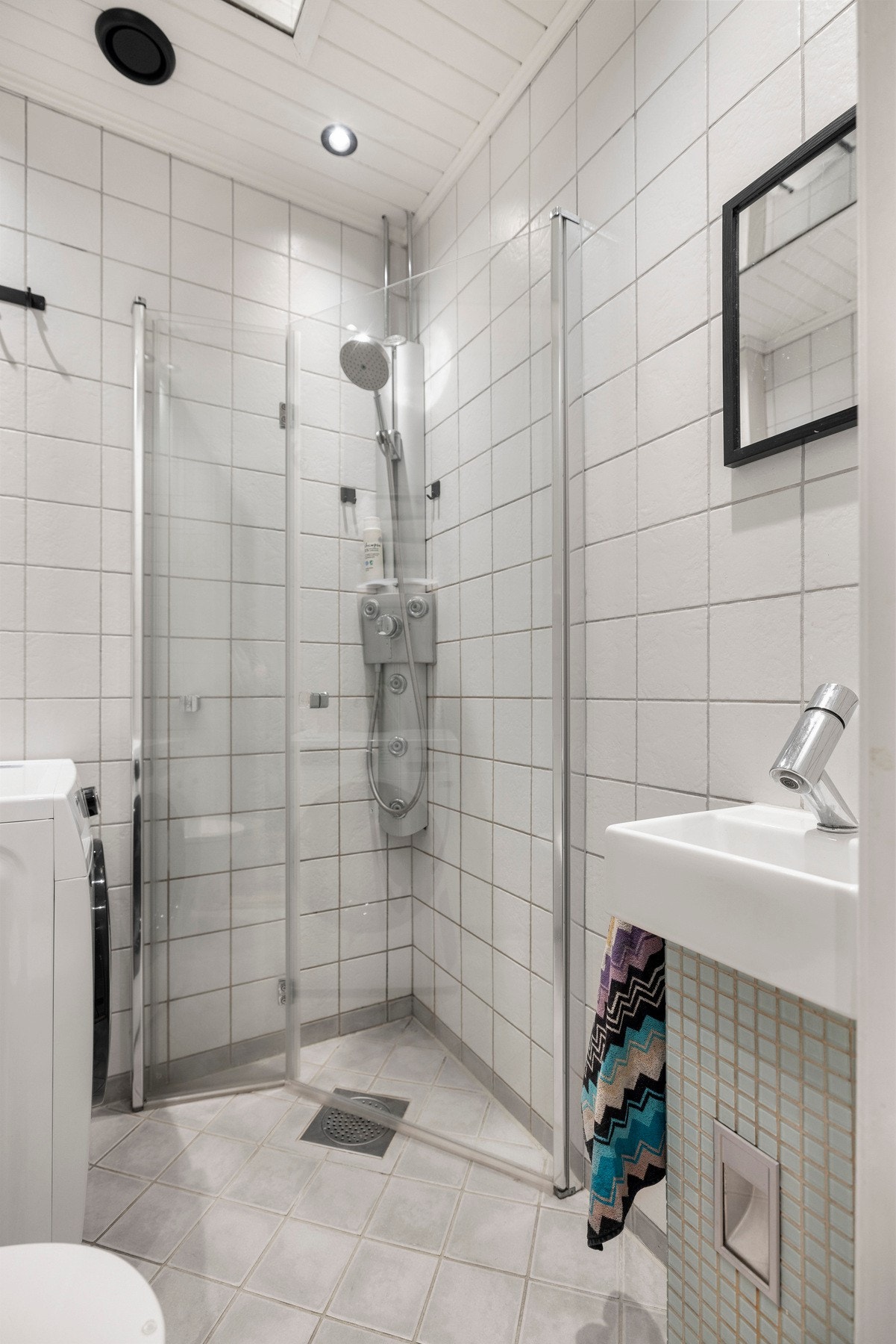 Flislagt bad med gulvvarme og praktiske, innfellbare dusjdører. Galleribilde