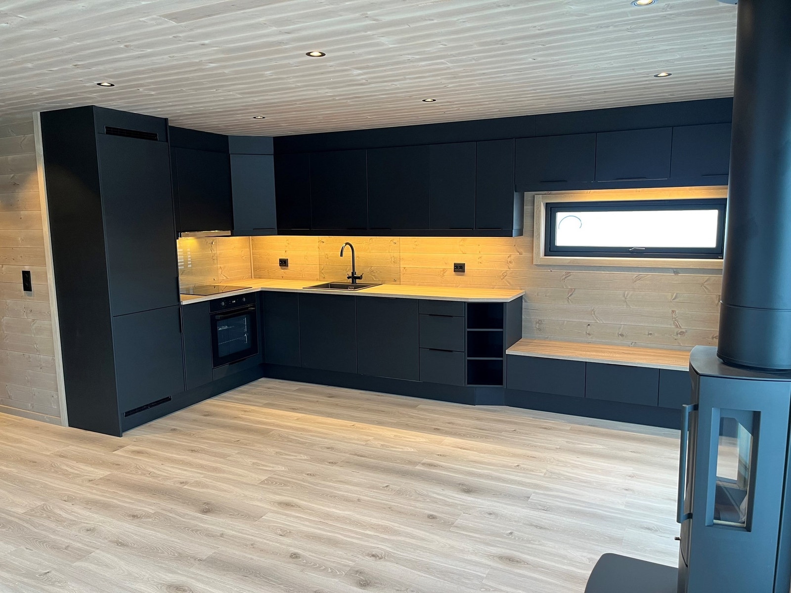 Praktisk sittebenk som en del av innredningen. Peisovn for kos og hygge. Galleribilde