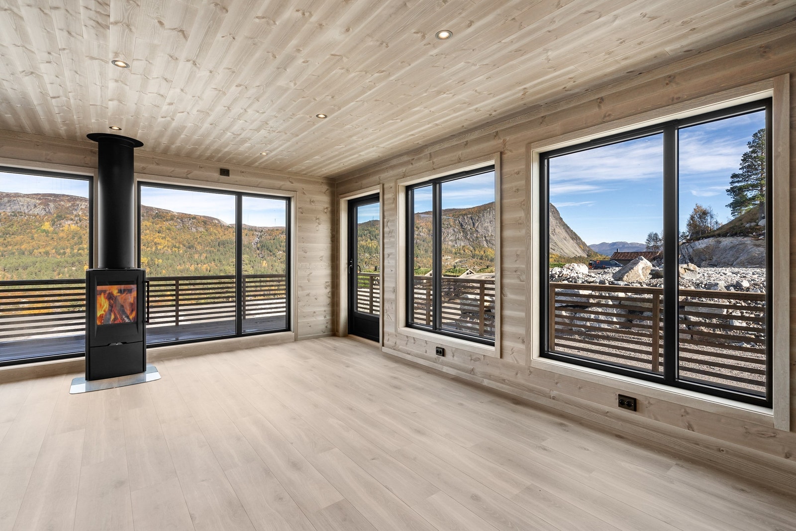 Flott stue med peisovn og store lysflater og vinduer. Utgang terrasse. Galleribilde