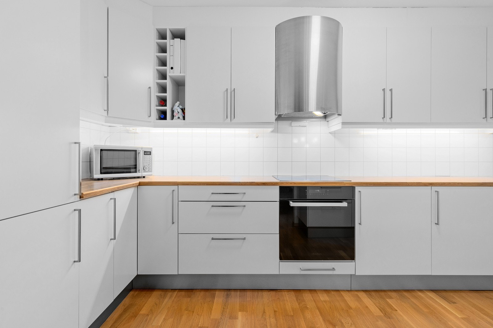 Kjøkken med stilrent design, integrerte hvitevarer og godt med oppbevaringsplass. Her har man god plass til matlaging og kontakt med gjester ved sosiale sammenkomster. Galleribilde