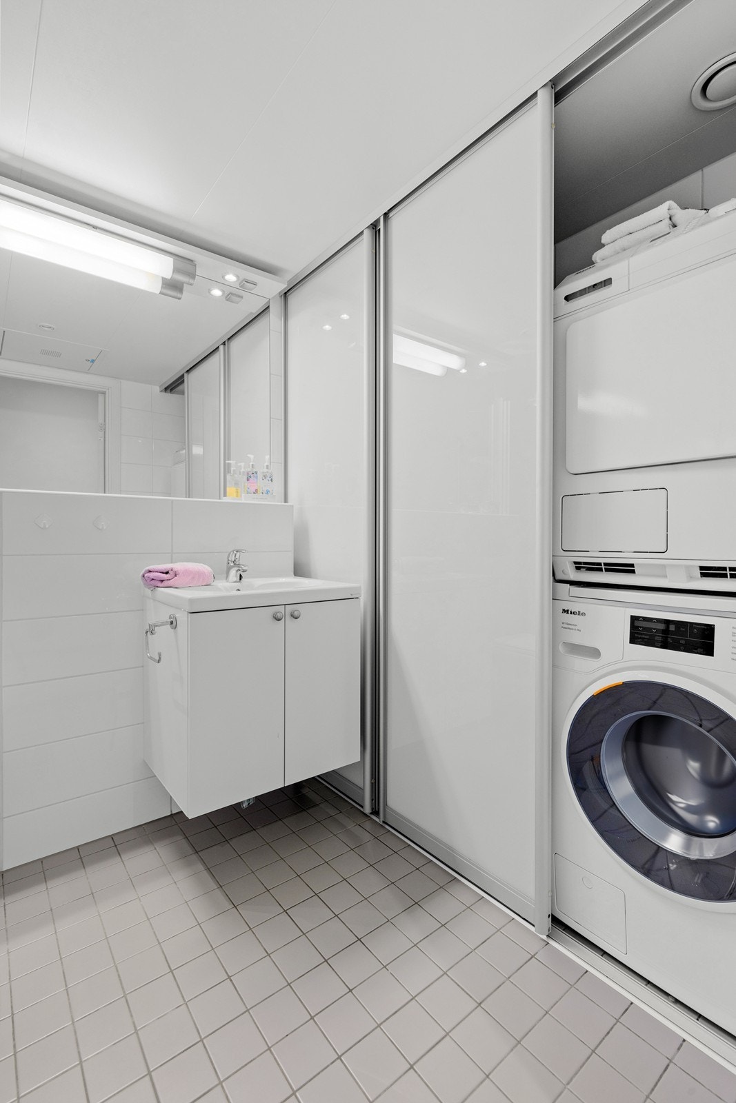 Badet har praktisk oppsett for vaskemaskin/tørketrommel, og god oppbevaringsplass. Perfekt for en effektiv hverdag Galleribilde