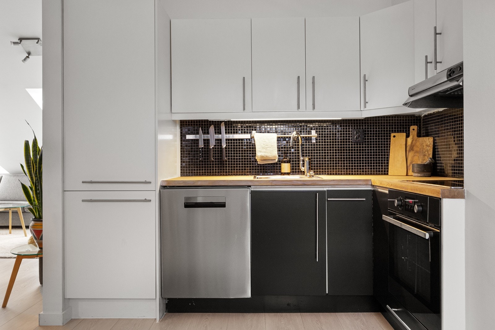 Kjøkkenet er innredet med integrerte hvitevarer som komfyr, keramisk platetopp og kjøl-/ fryseskap Galleribilde