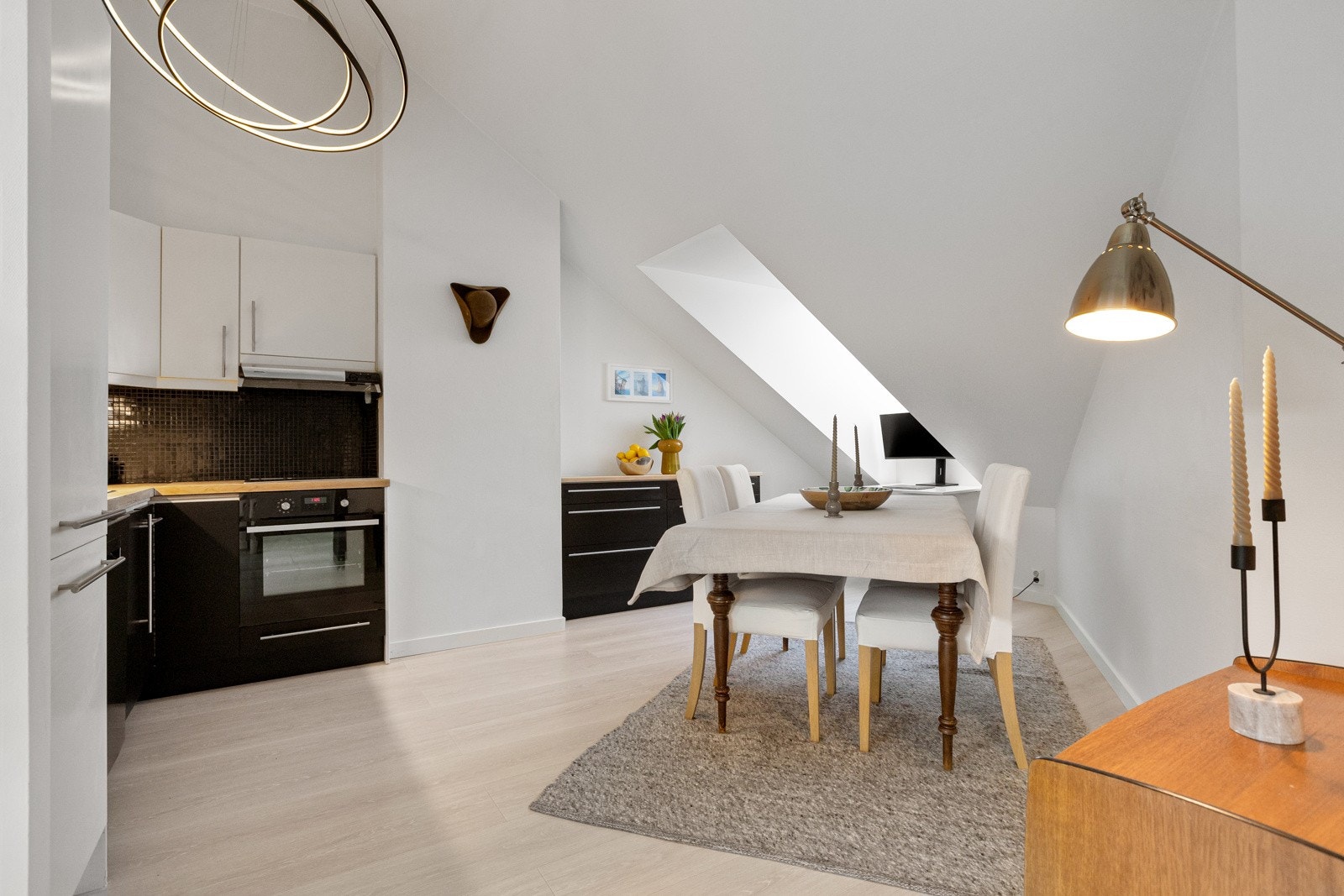 Her er kjøkkenet utført i en praktisk L-form og har glatte fronter Galleribilde