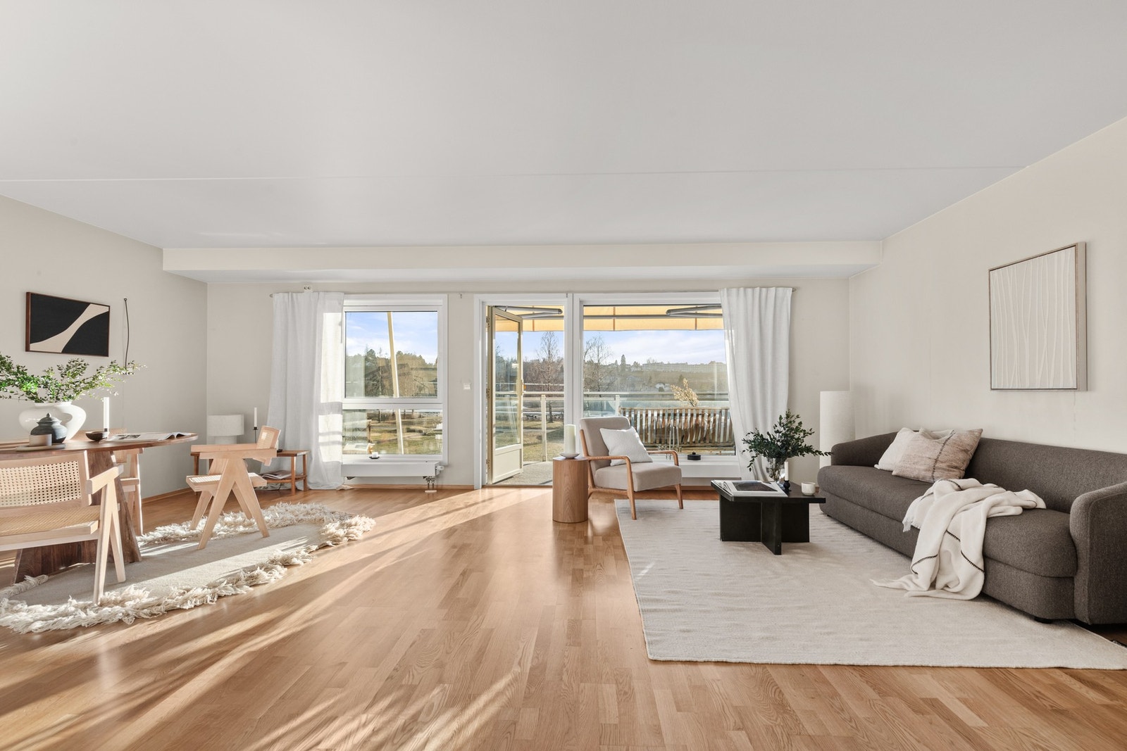 Leiligheten har en fin romfølelse og vinduer fra gulv til tak lar lyset flyte fritt innover leiligheten og skaper en sval stemning Galleribilde