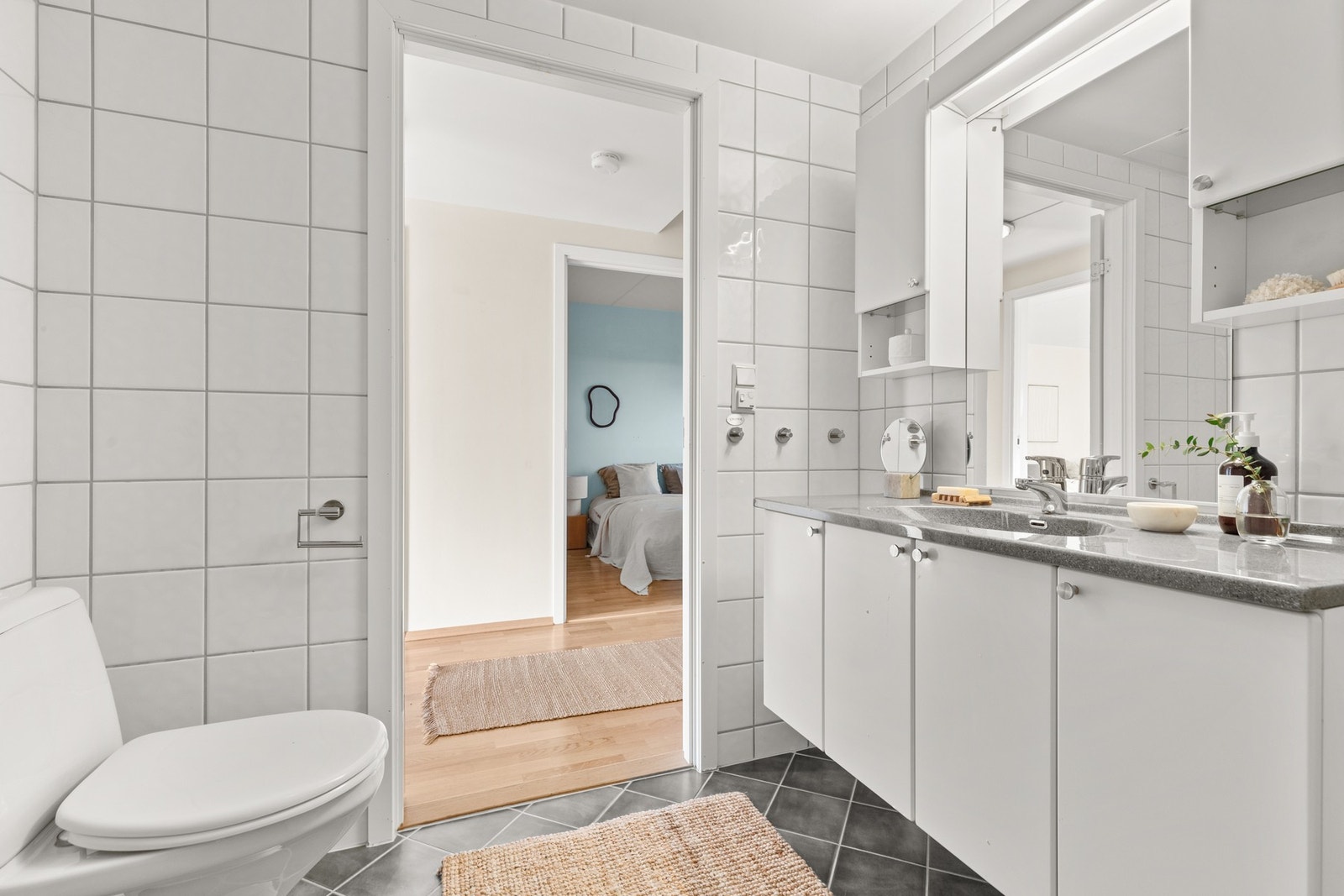 Badet ligger i tilknytning til gangen, er av god størrelse og innredet i tidløse hvite og grå toner, som gir en behagelig start på dagen. Galleribilde