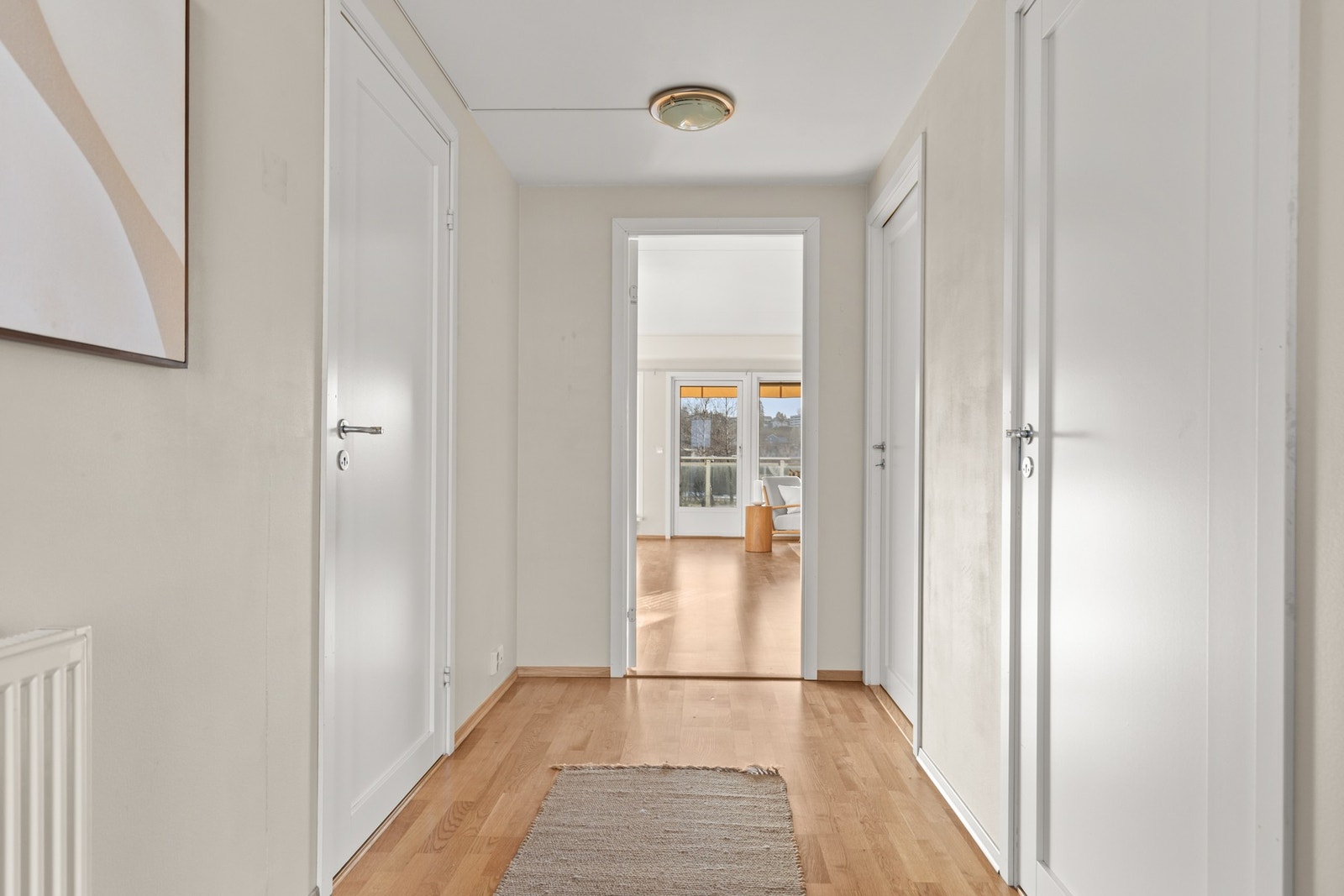 Innvendig møtes du av en lys og romslig entré og gang, som gir en hyggelig velkomst inn i boligen Galleribilde