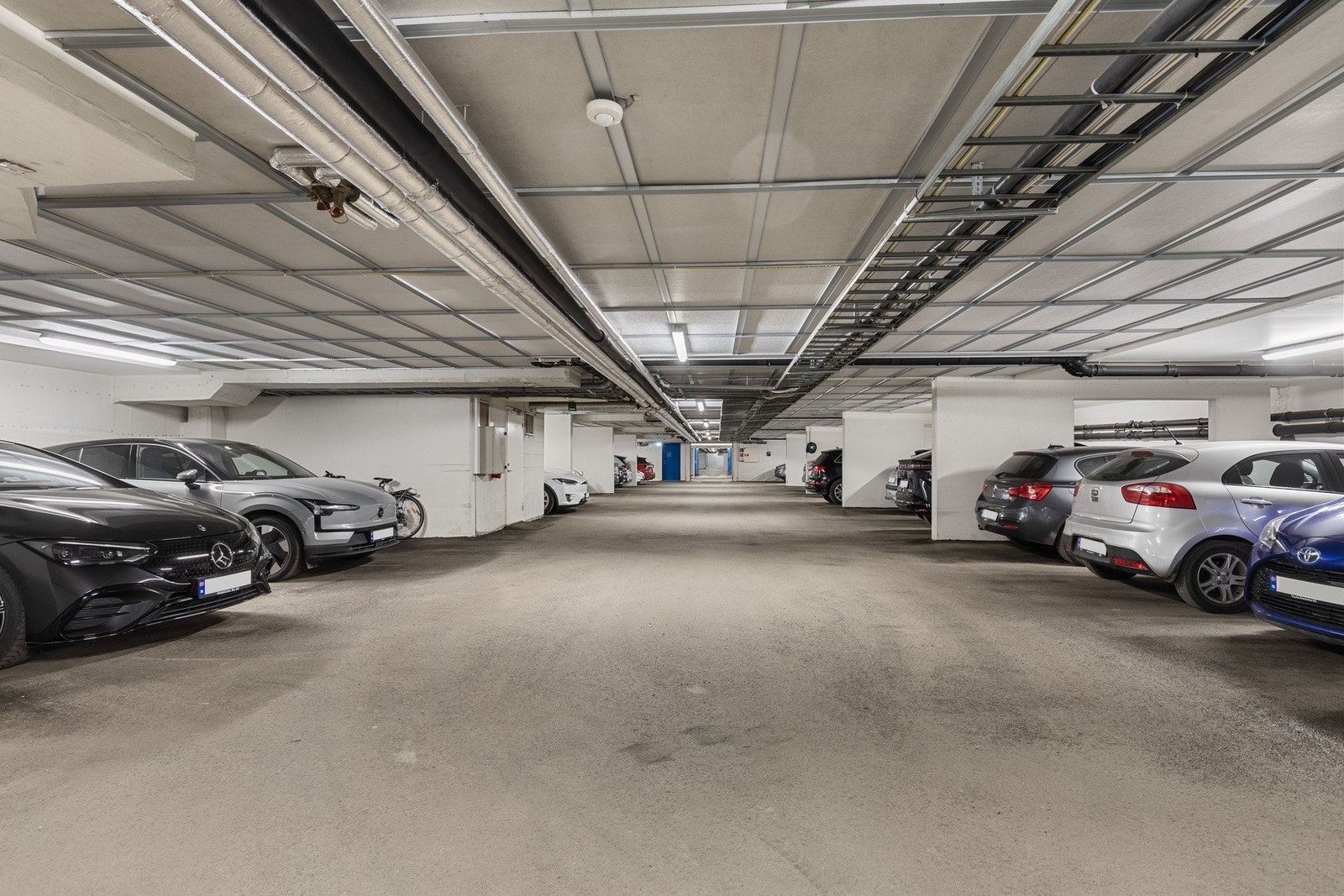 Det medfølger en egen garasjeplass i oppvarmet garasjeanlegg under bygningen. Det er mulighet for elbillader. I tillegg er det en stor bod på 3 kvm i kjelleren. Galleribilde