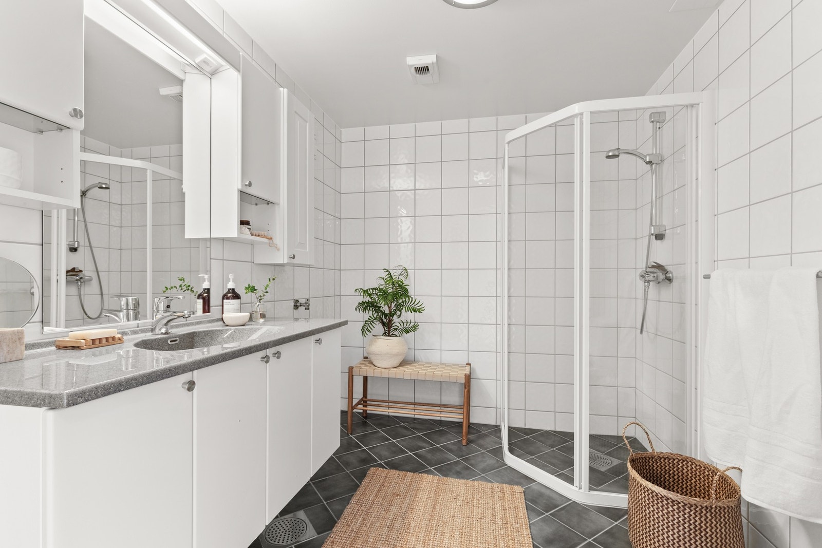 Badet er innredet med dusjnisje i herdet glass og romslig innredning med heldekkende servant. Det er opplegg for vaskemaskin/tørketrommel ved siden av innredningen. Galleribilde