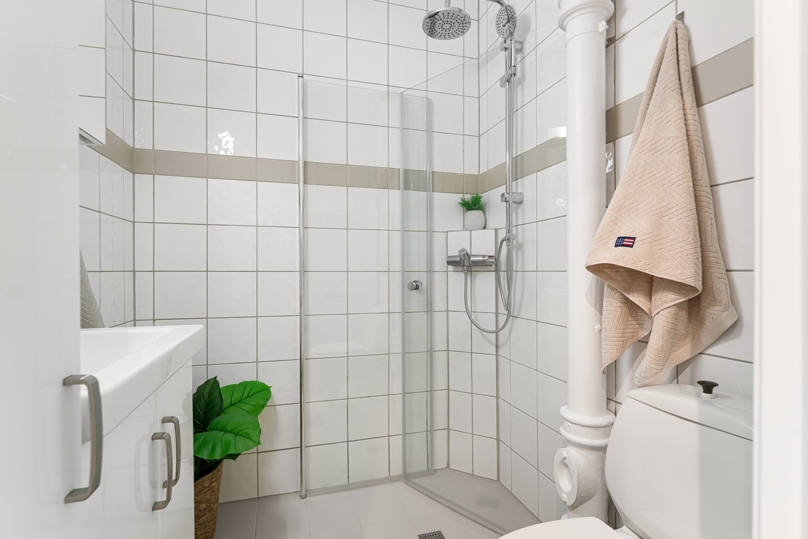 Lyst, helfliset baderom med gulvvarme og et romslig dusjhjørne. Det er tilgang til en felles vaskekjeller i sameiet. Galleribilde