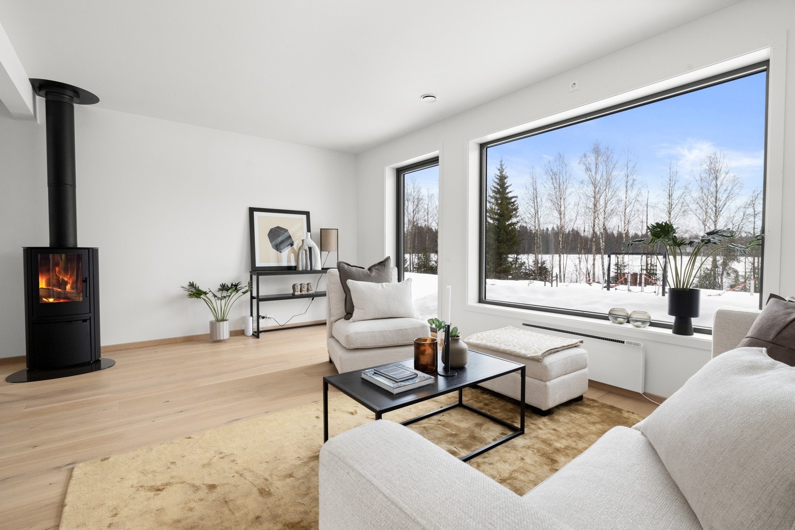 Den flotte peisovnen midt i rommet varmer godt på kalde dager og gir en god atmosfære varme og hygge. NB! Bildene er hentet fra tilsvarende bolig i prosjektet. Galleribilde