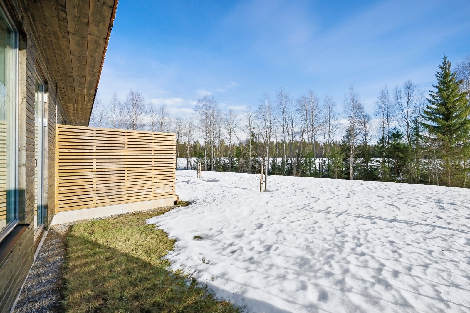 Via terrassedøren er det utgang til en sydvendt uteplass, pent opparbeidet med plen. Det er satt opp levegg mot nabo. Galleribilde