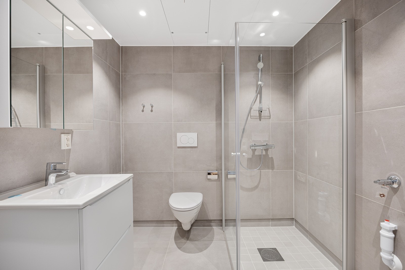 Baderommet er i moderne stil med 60x60 flis på gulv og vegger med 10x10 fliser i dusjsonen. Galleribilde