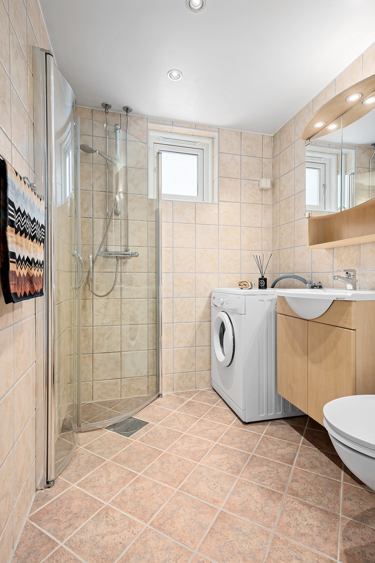 Pent bad/wc med opplegg til vaskemaskin. Det er vindu på badet. Galleribilde