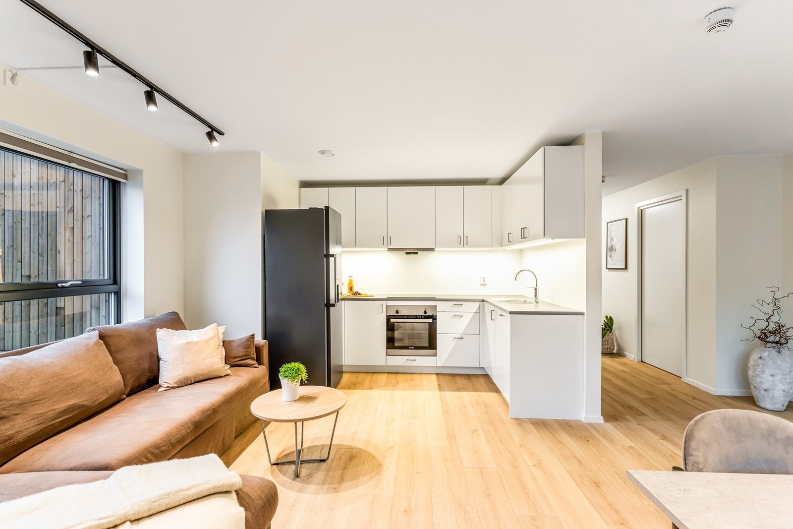 Rommet har en funksjonell utforming med god plass til sofagruppe, spisebord og tv-møblement. Galleribilde