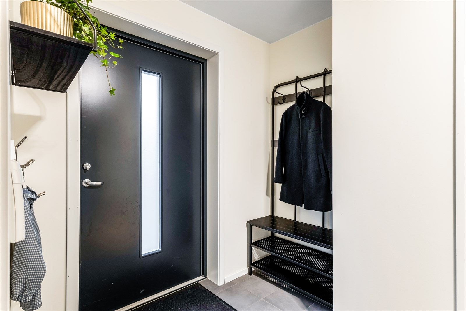 Entréen har flislagt gulv og inneholder en praktisk garderobenisje. Galleribilde
