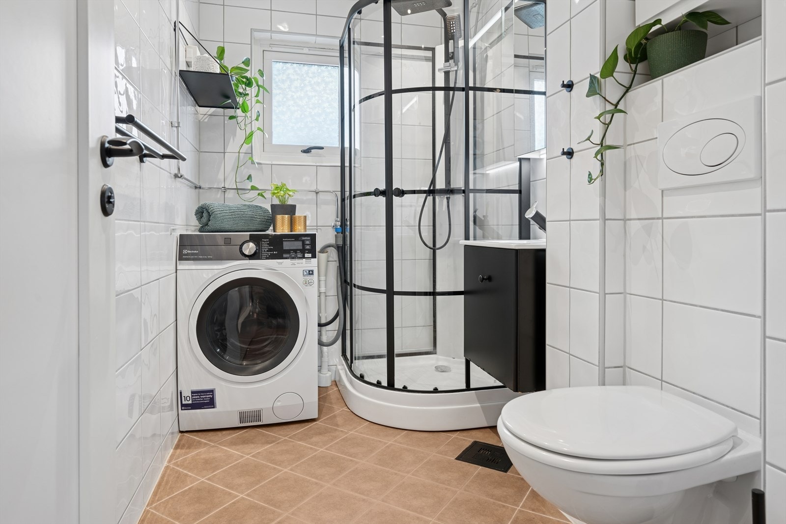 Badet er utstyrt med vegghengt toalett, servant med lagring, speilskap, dusjkabinett og opplegg for vaskemaskin. Det er selvfølgelig gulvvarme for god komfort året rundt. Galleribilde