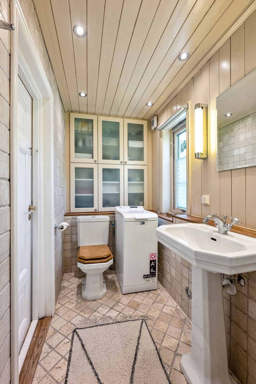 Badet er innredet med en enkel søyleservant, speil, toalett og dusj. Det er også opplegg for vaskemaskin. Galleribilde
