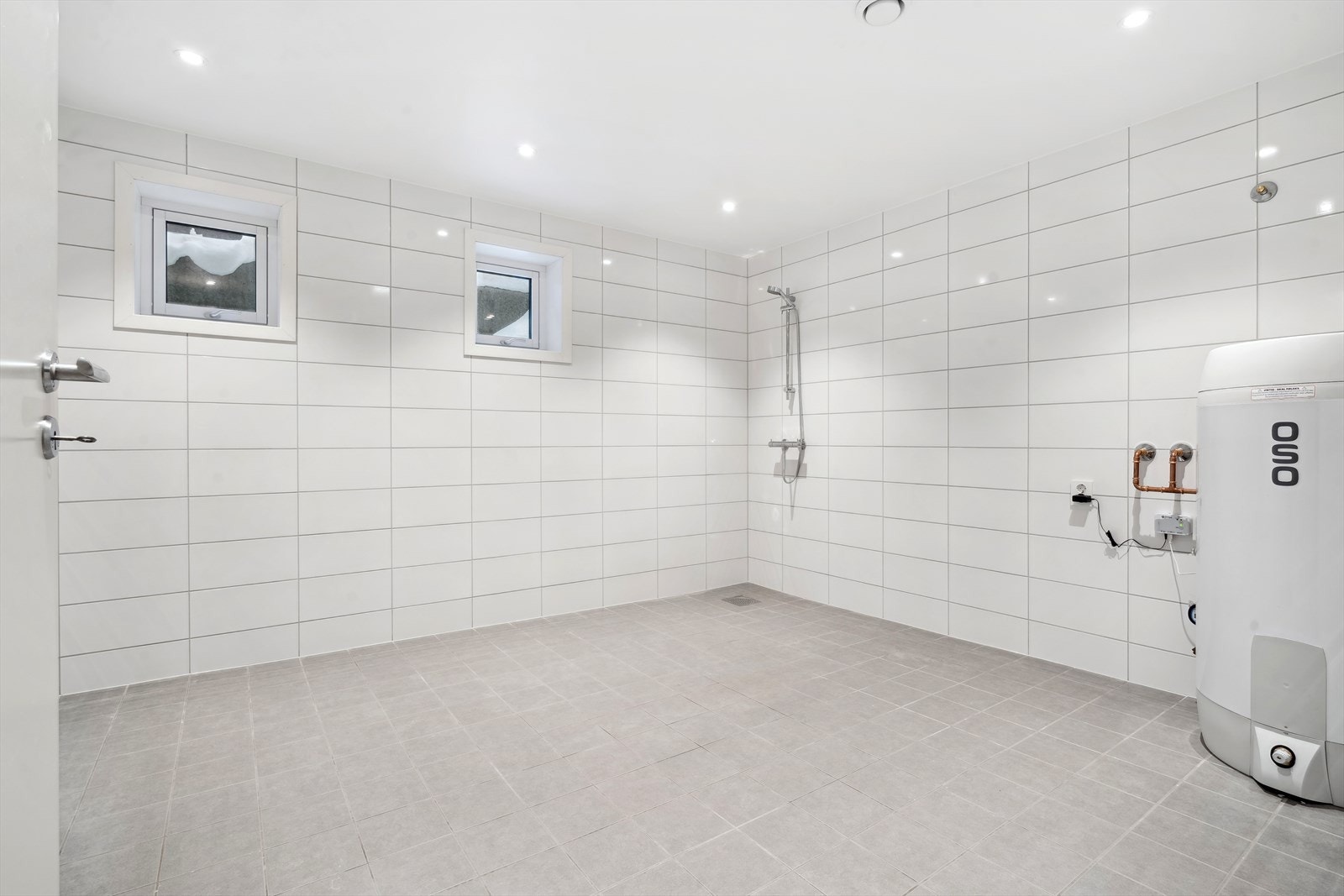 Stort og romslig vaskerom/bad på 12,5 m², her finner du blant annet varmvannbereder, rørfordelingsskap, stoppekran og vannmåler. Det er også gulvvarme, ferdig opplegg for vaskemaskin og dusjhjørne. Galleribilde