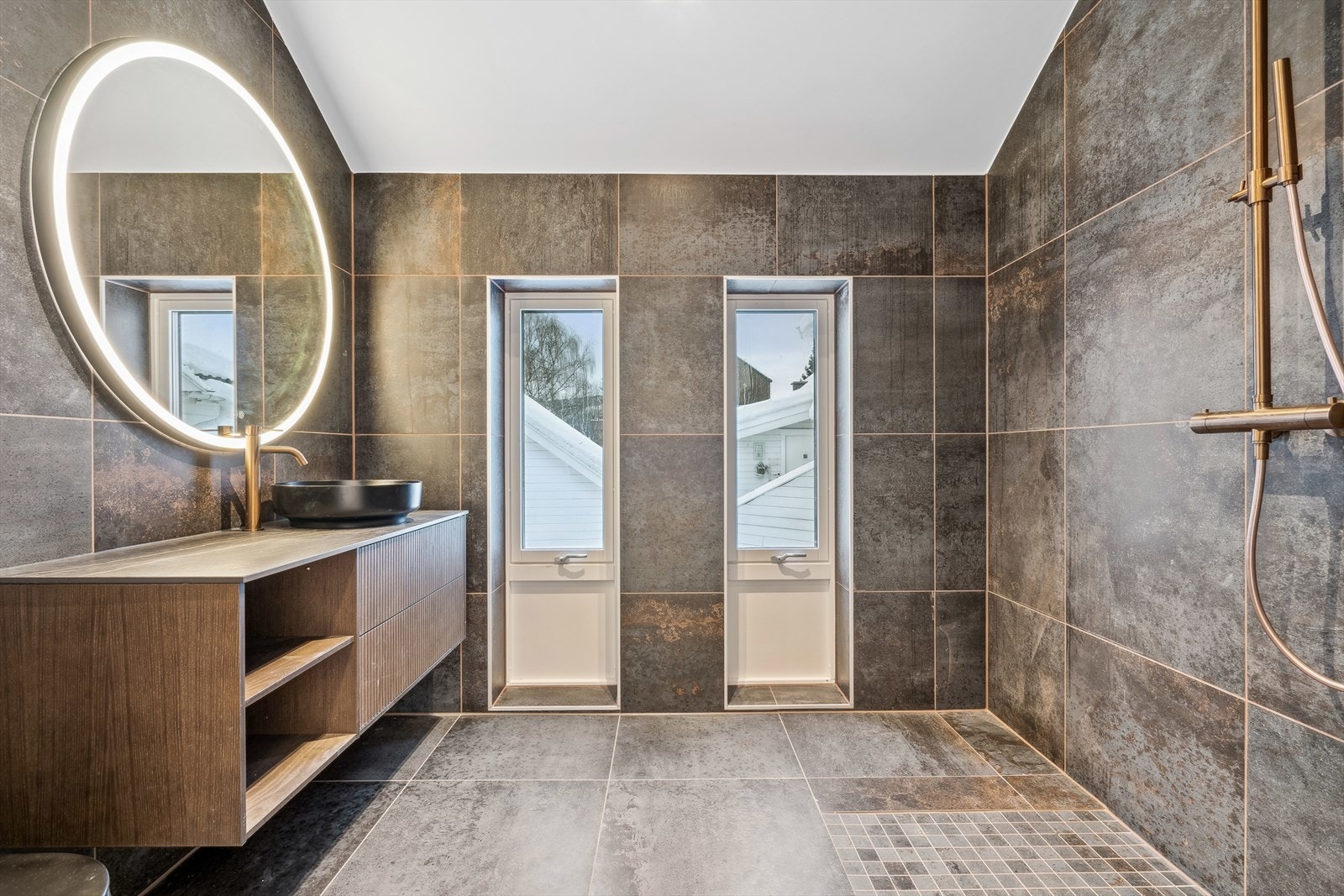 Boligen har tilsammen 4 baderom. Det delikate og moderne badet er utstyrt med store, flotte fliser på både gulv og vegger, i tillegg til elegant dusjgarnityr og moderne baderomsinnredning. Galleribilde