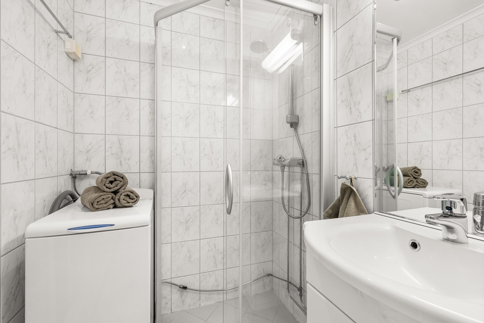 Badet er innredet med opplegg for vaskemaskin, dusjhjørne, toalett og servant med innredning. Varmekabler er defekte. Galleribilde