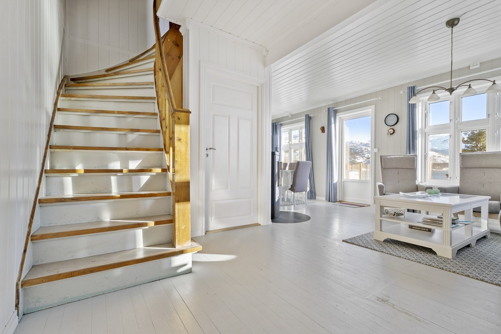 Innenfor vindfanget er det en lys og trivelig stue med rikelig lysinnslipp Galleribilde