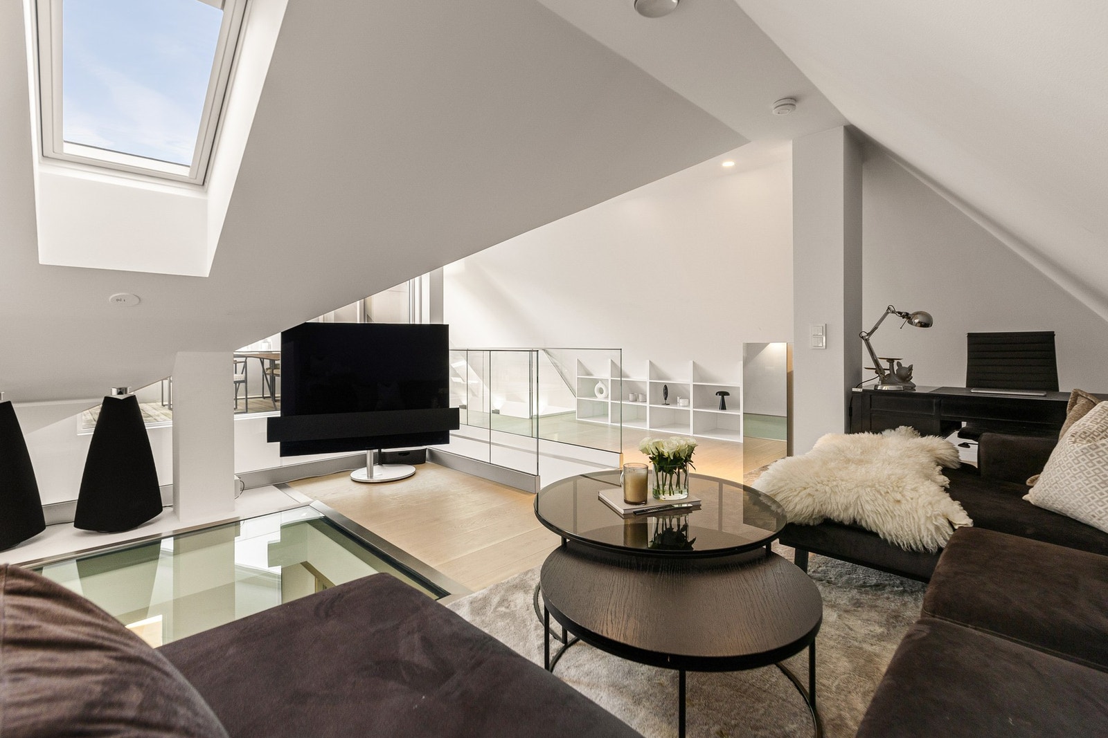 Den romslige TV-stuen får et naturlig lysinnslipp fra et elegant skråtaksvindu, som skaper en lys og innbydende atmosfære. Galleribilde