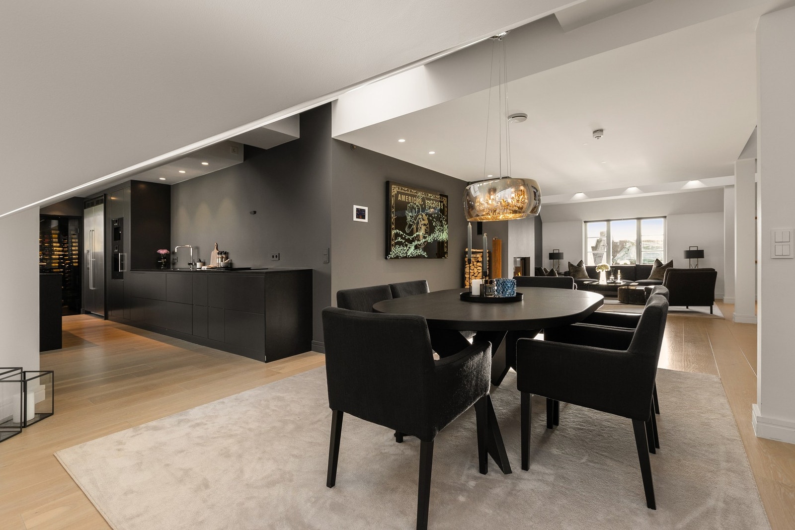 Stuen harmonerer med et moderne kjøkken i en delvis åpen løsning, som skaper en luftig og sosial atmosfære. Galleribilde