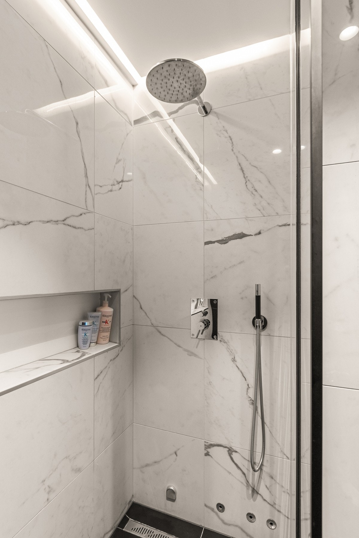 Dusjsonen har en delevegg av glass og nisje på veggen for oppbevaring. Galleribilde