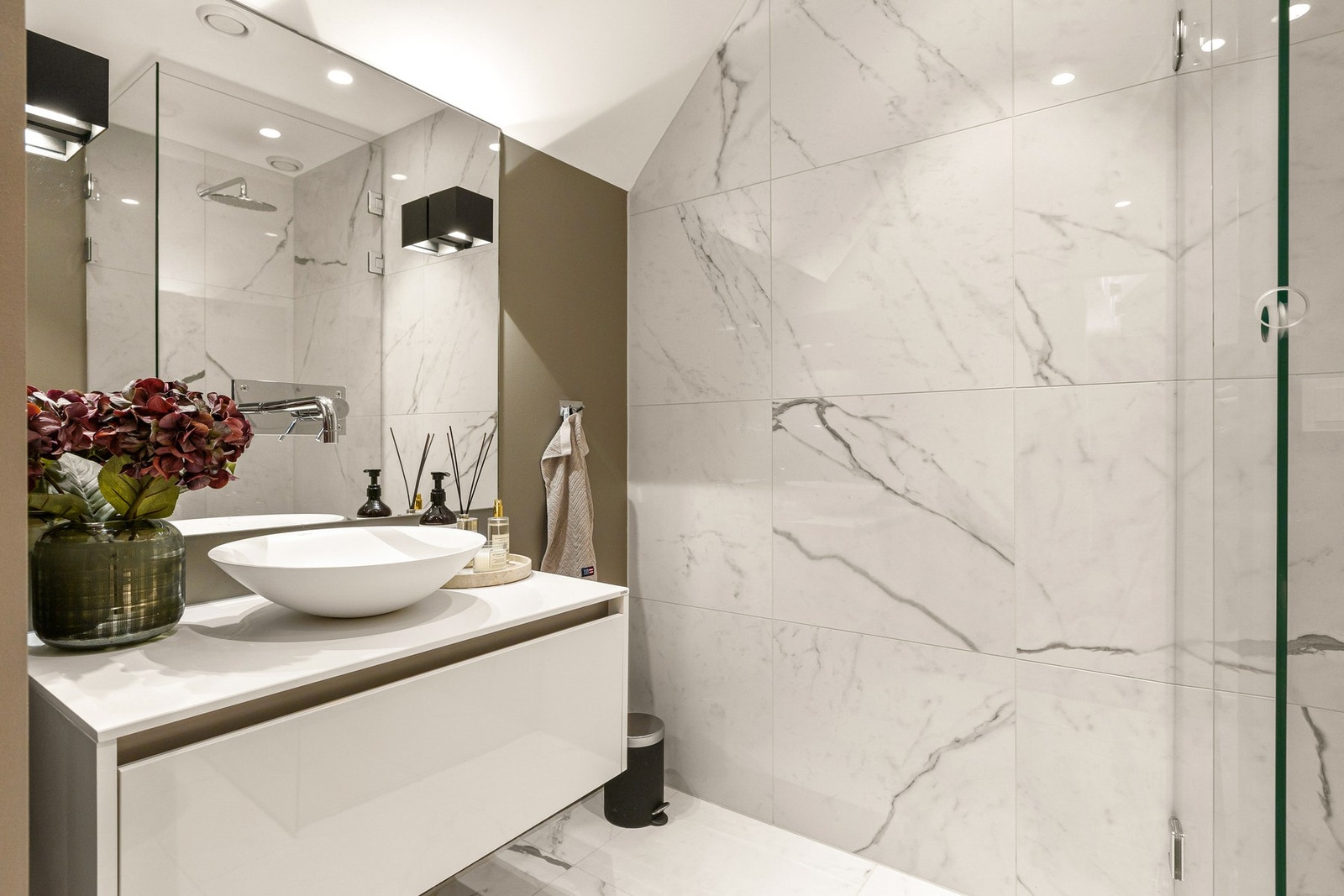 Badet er flislagt med varme i gulv, malte flater og nedsenket himling med downlights. Videre har badet vegghengt toalett og mekanisk avtrekksventil i himlingen. Galleribilde