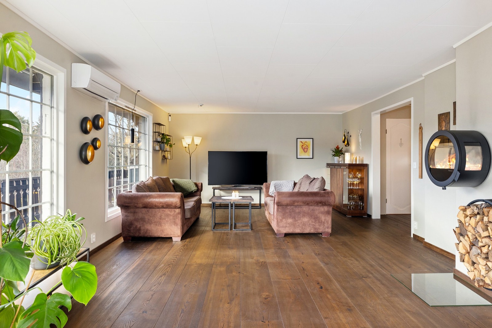 Det første du ser når du går inn i stuen er de store vindusflatene med utsikt mot hagen og omkringliggende områder. Galleribilde