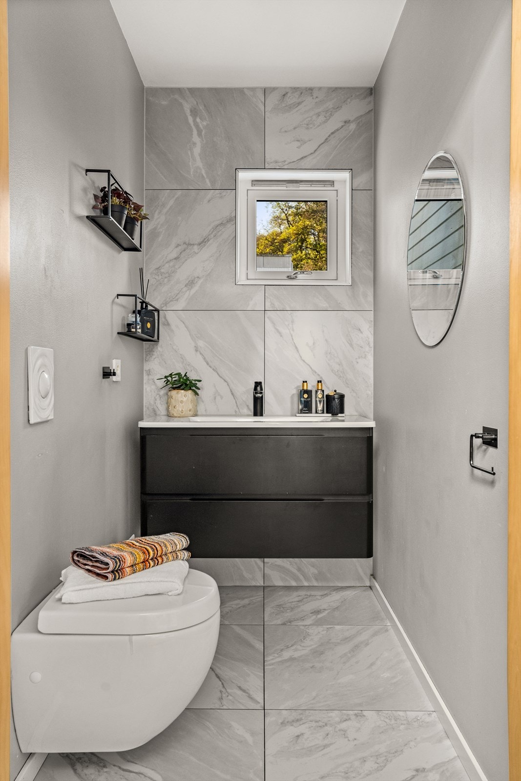 Toalettrom i 1. etasje er utstyrt med vegghengt toalett og servantinnredning. Overflater ble pusset opp i 2024 og fremstår i god stand. Galleribilde