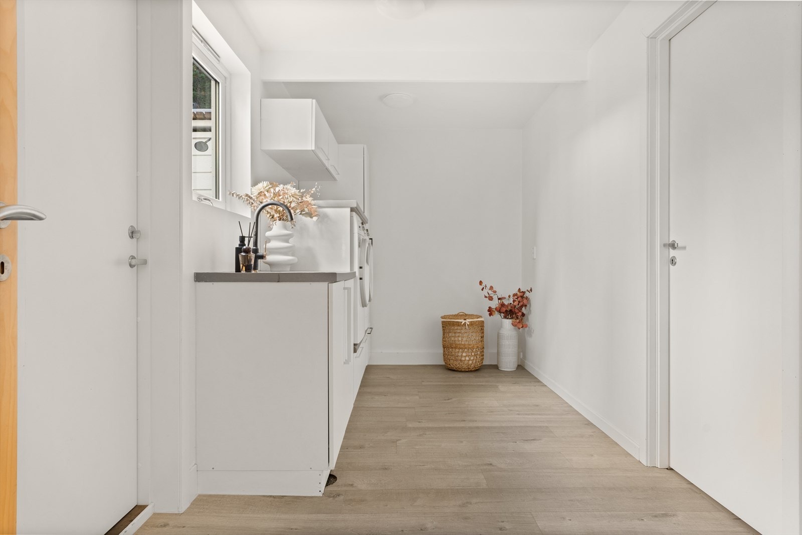 Vaskerommet er utstyrt med innredning med benkeplate og underlimt vask, oppbevaringsskap og sikringsskap.
Rommet ligger i åpen løsning med garasjen - Dette er ikke en godkjent løsning. Galleribilde