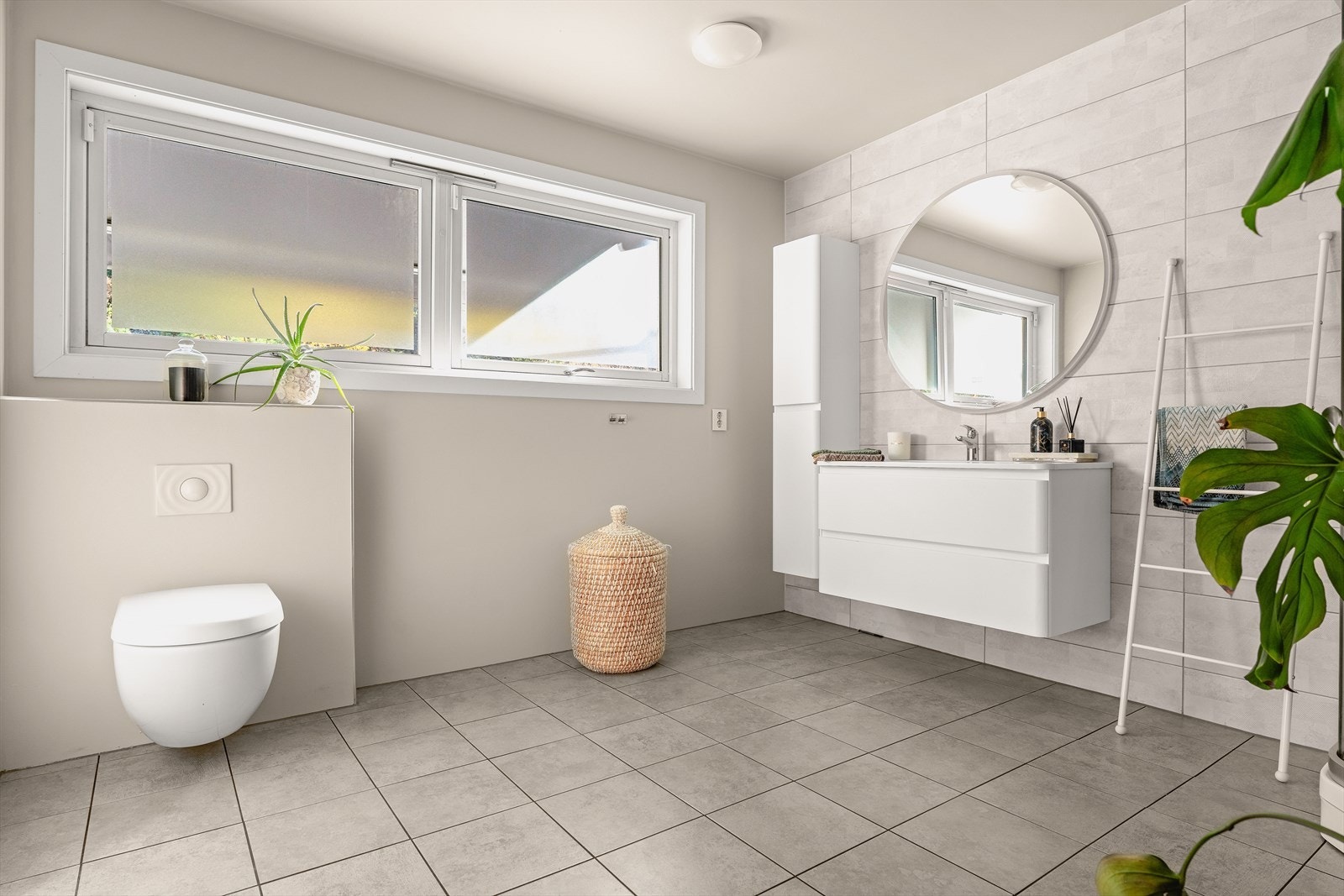 Badet er utstyrt med dusjkabinett, servantinnredning, oppbevaringsskap og vegghengt toalett. Galleribilde