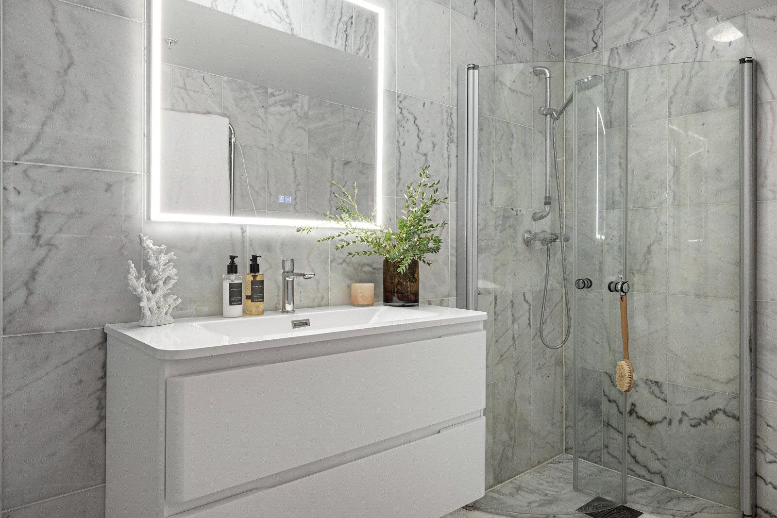 Over servanten er det et veggmontert speil med integrert belysning og touch-funksjon. Galleribilde