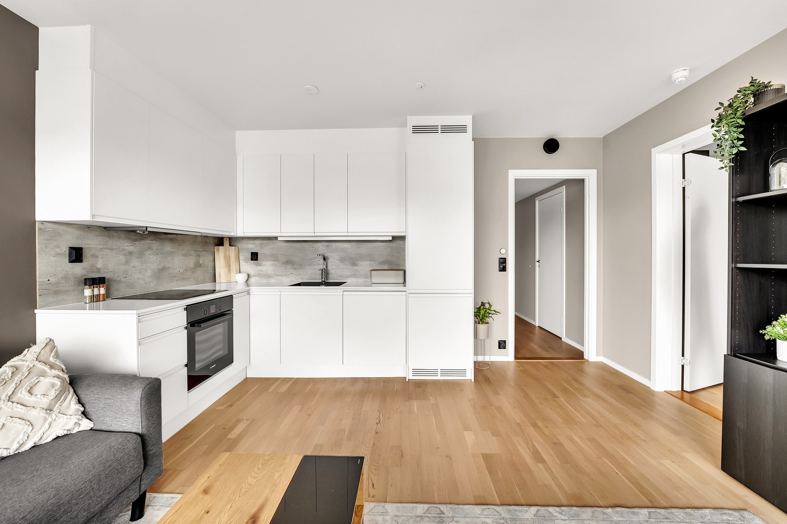 Flott kjøkkeninnredning fra drømmekjøkken med hvite grepsfrie fronter, 20mm hvit laminat benkplate i høyglans med en stilren underlimt vaskekum. Galleribilde