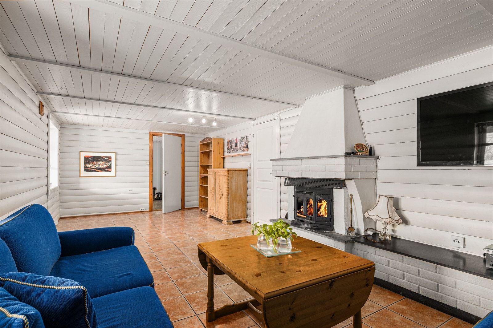 Kjellerstua med "tømmerpanel og peis med innsats. Galleribilde