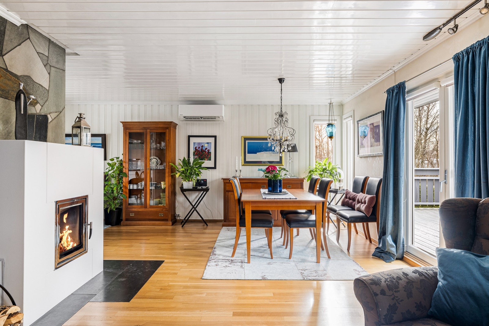 Flammene i den moderne peisen kan sees fra sofa og spiseplass. Galleribilde