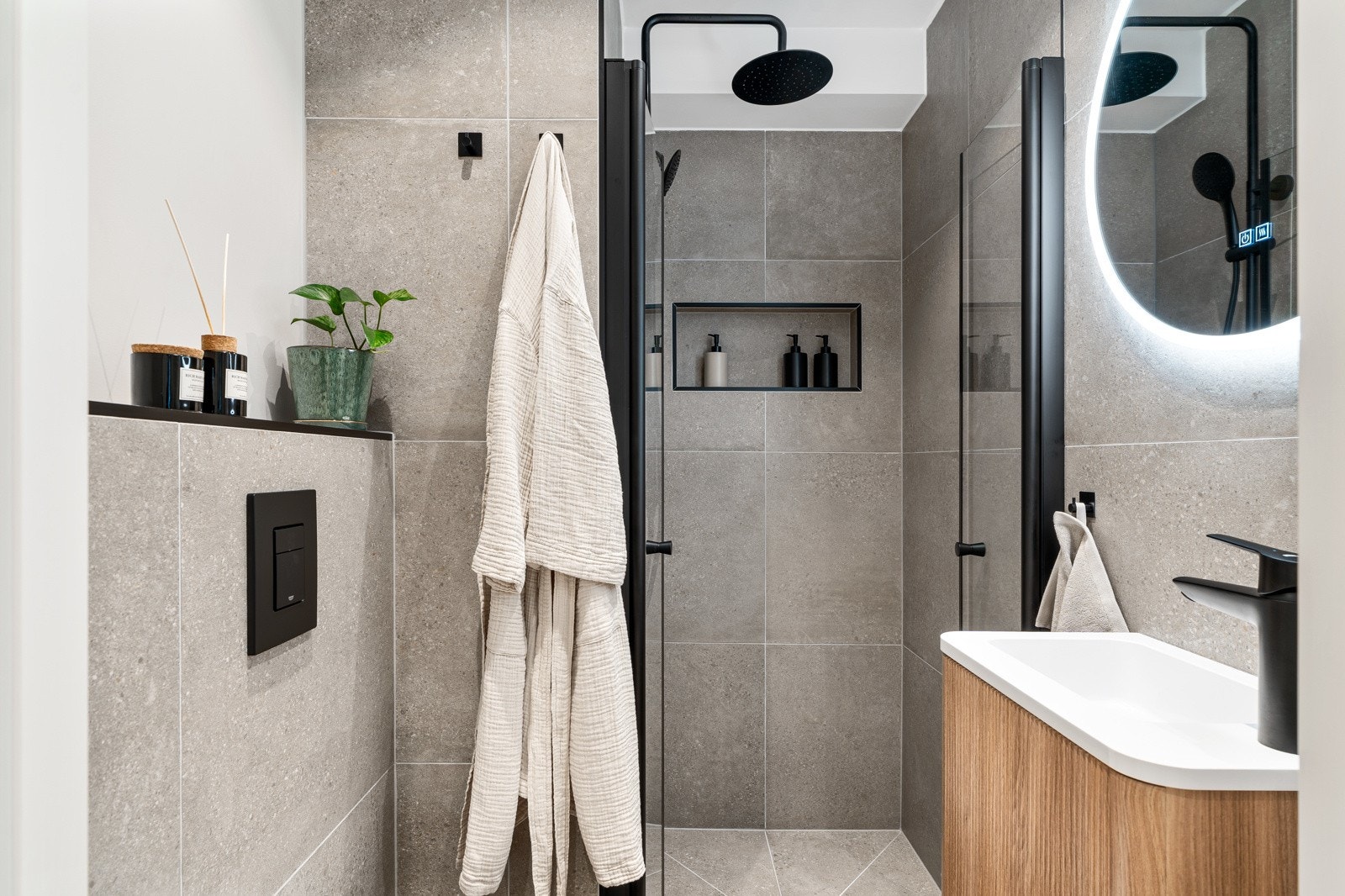 Leiligheten har et gjennomført bad med moderne flisvalg og gulvvarme. Galleribilde