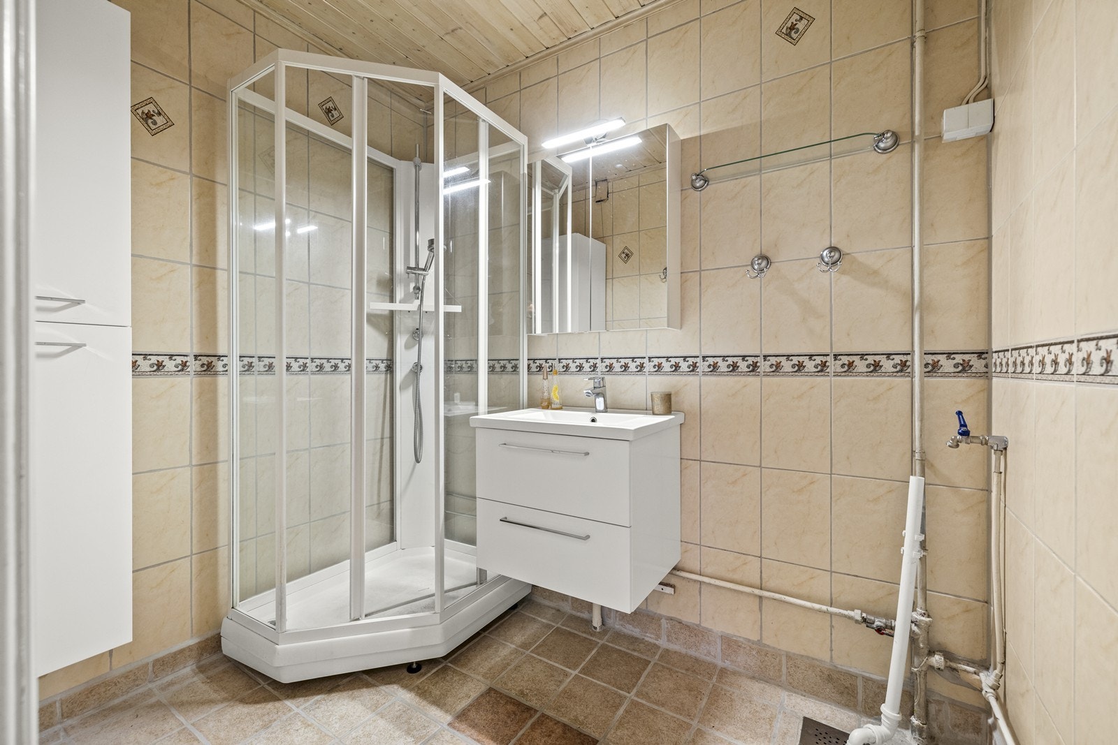 Badet har innredning med nedfelt servant, dusjkabinett og opplegg for vaskemaskin. Galleribilde