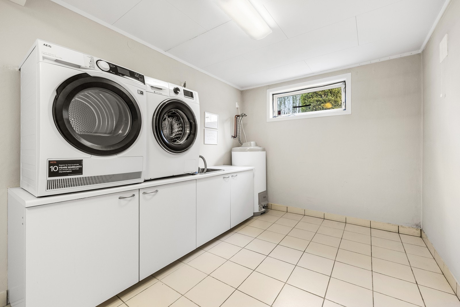 Vaskerom i kjelleren med innredning og opplegg til vaskemaskin. Galleribilde